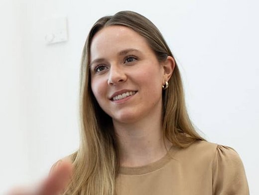 Drei jüngere Kollegen sprechen in einem Aufenthaltsraum miteinander