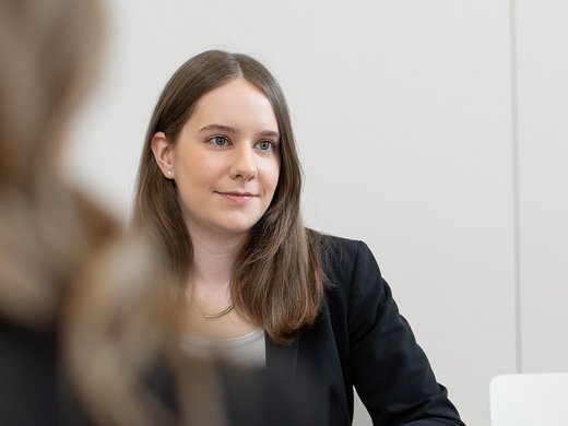 Eine jugne Frau sitzt in einer Besprechung